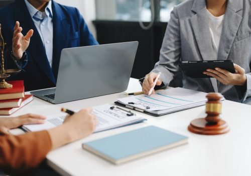 Business law concept, Lawyer business lawyers are consulting lawyers for women entrepreneurs to file copyright lawsuit with laptop and tablet at office